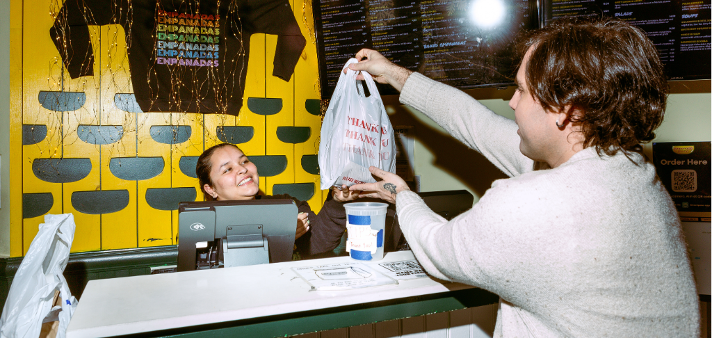Restaurant server behind the counter at Empanada Mama
