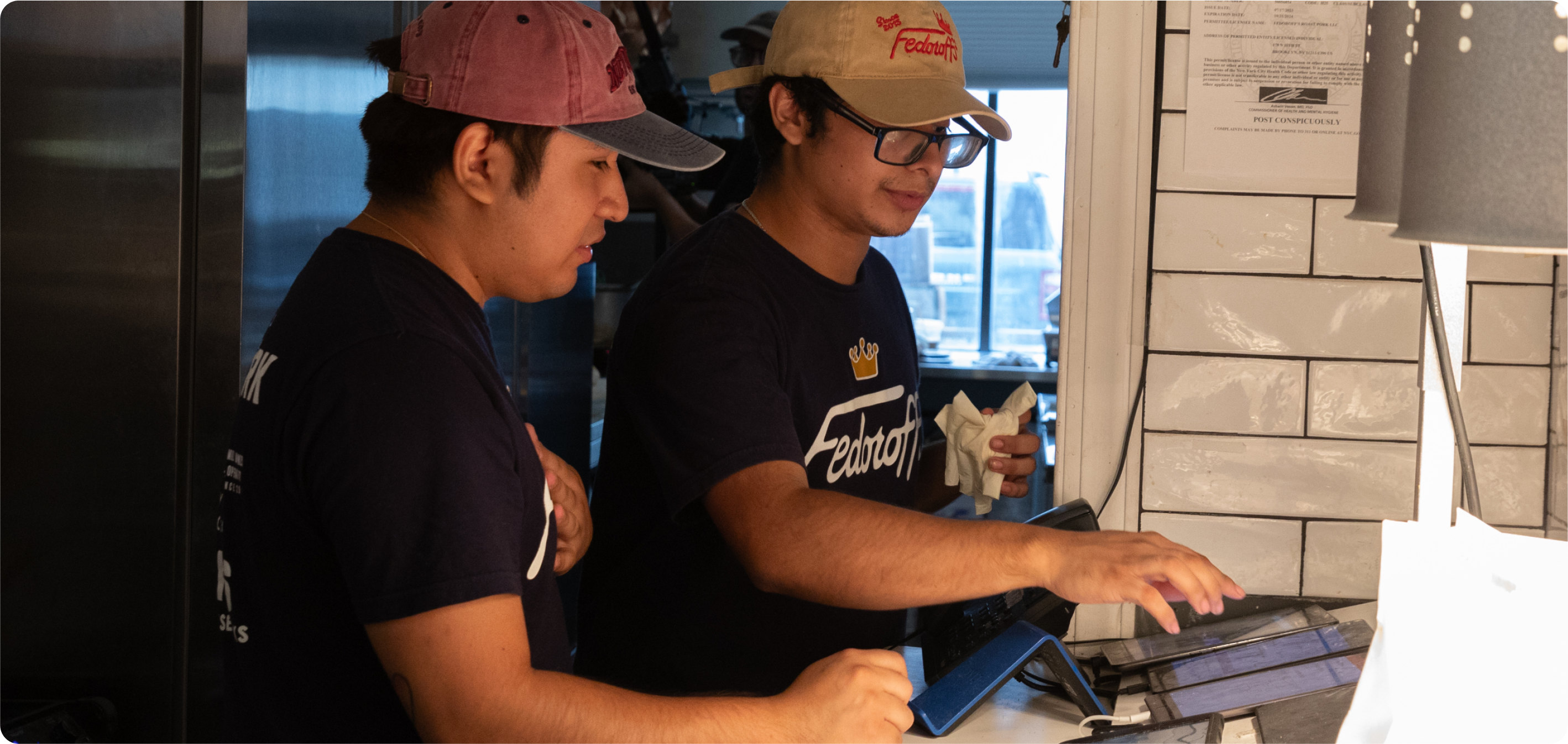Restaurant staff managing multiple tablets