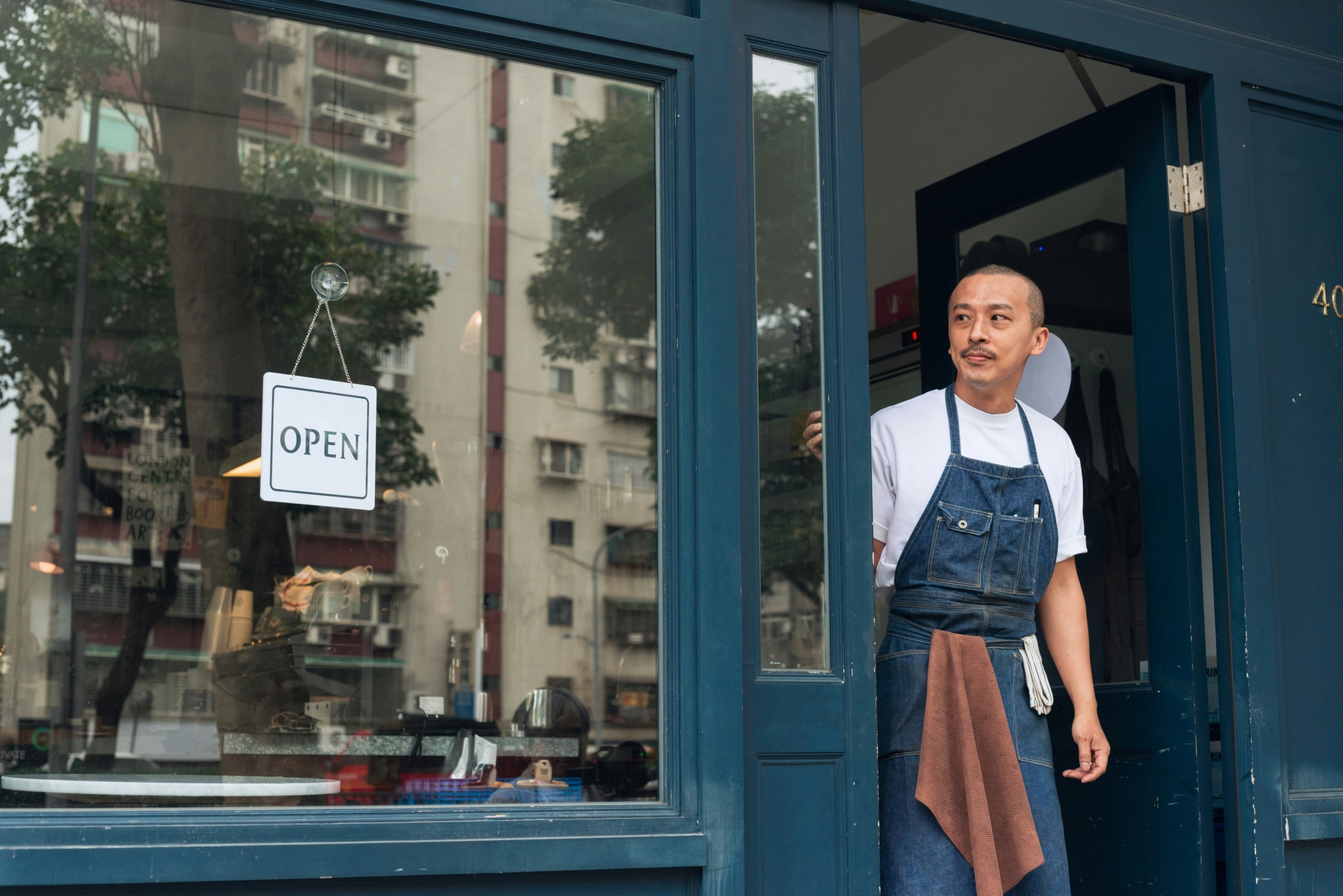 Restaurant operator in door with open sign
