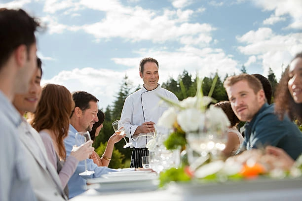 chef at head of table full of people