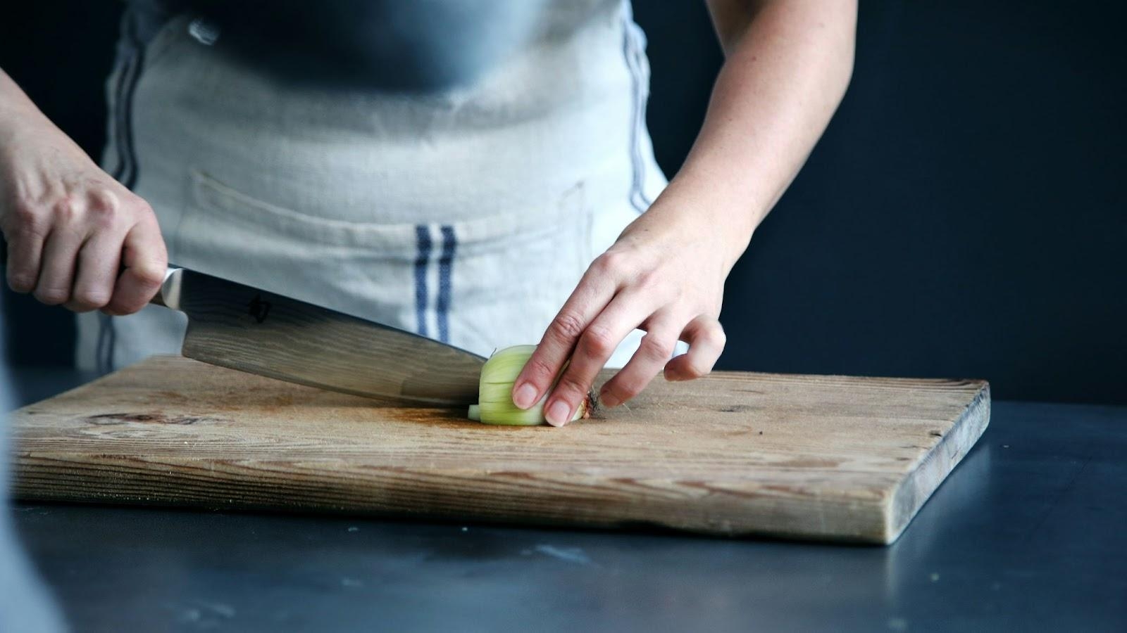 person cutting cucumber with knife
