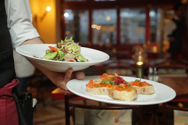 person serving dishes to customers