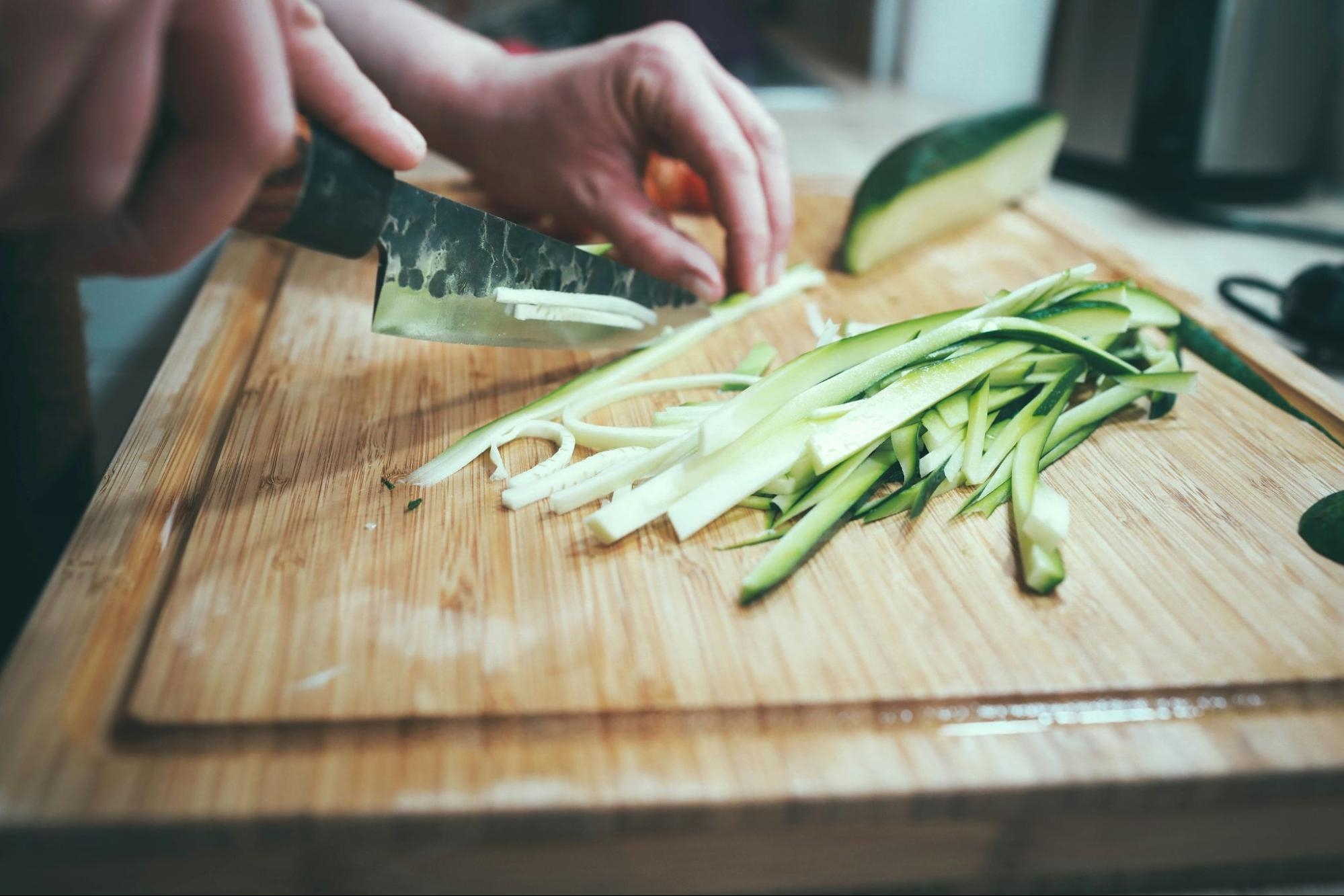 close up of person cutting cucumber