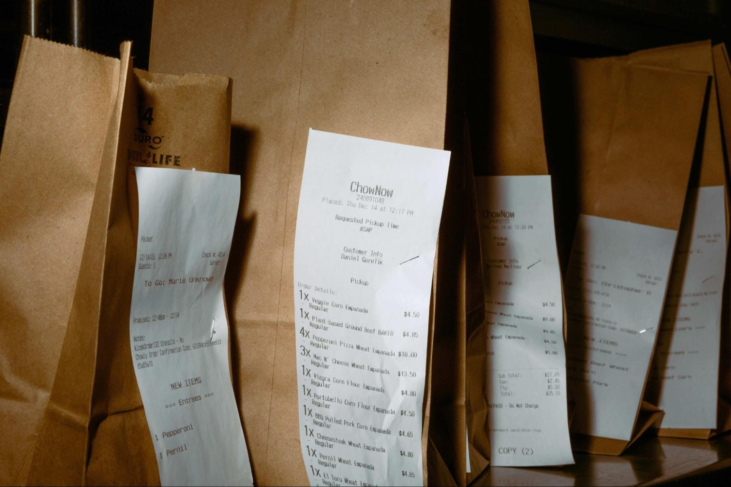 line of takeout bags at restaurant with receipts