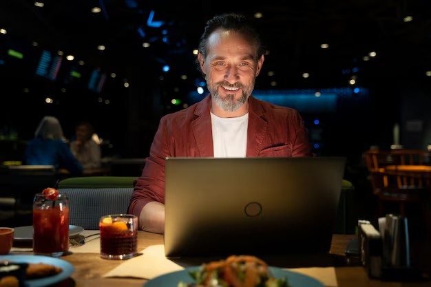 person grinning on computer in restaurant
