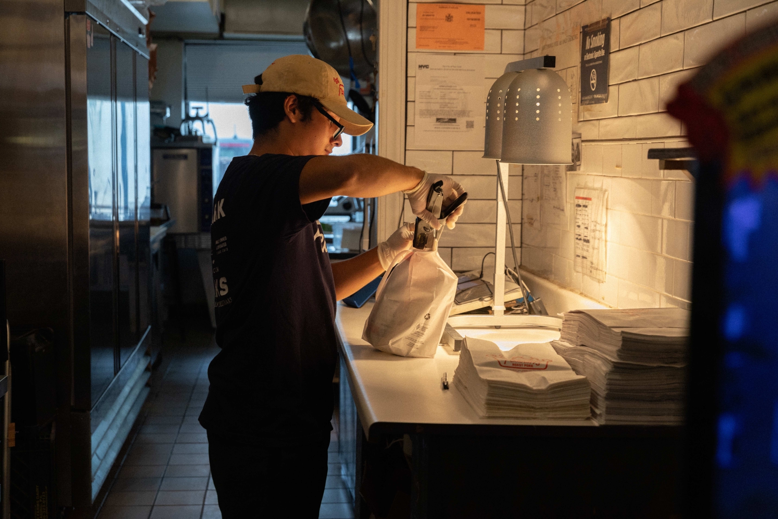 restaurant staff tying up takeout bag