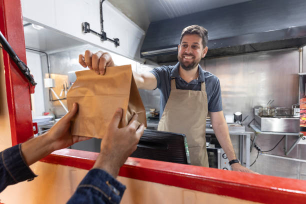 restaurant staff handing takeout to customer