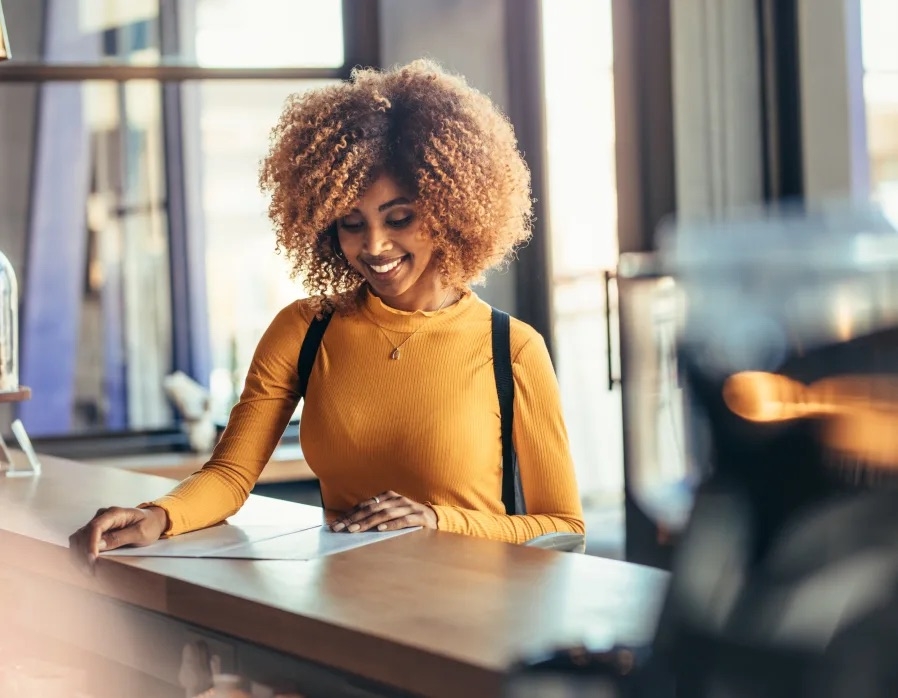 A restaurant operator reviews paperwork behind the counter, representing the operational challenges order aggregation helps simplify across multiple ordering platforms.