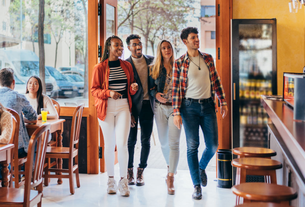 a photo of a group of diners walking into a busy restaurant, ready to be seated.