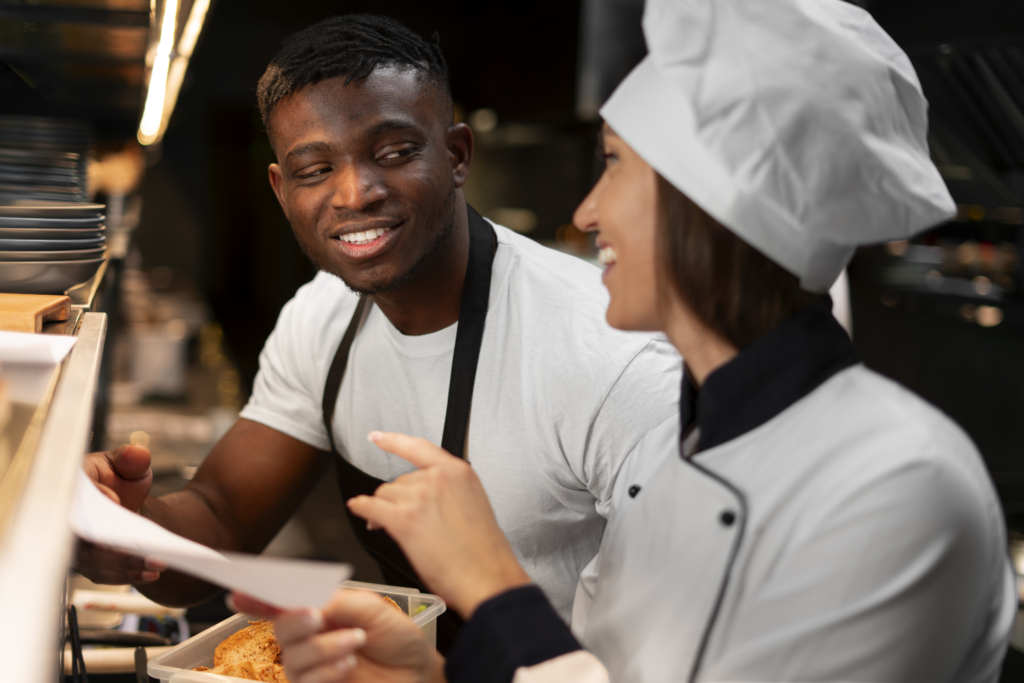 Restaurant kitchen team reviewing an order ticket together during service.