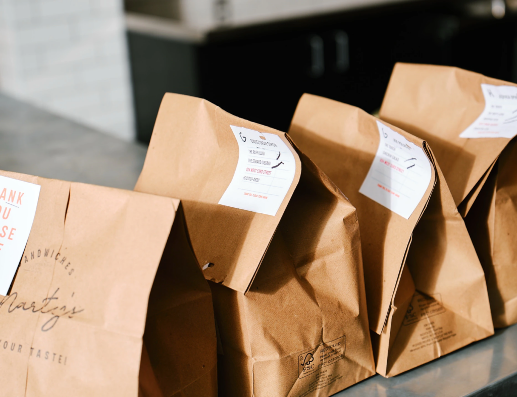 Row of labeled restaurant takeout bags lined up for pickup or delivery orders