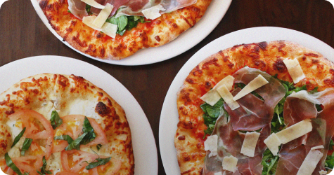 Three pizzas on plates viewed from above